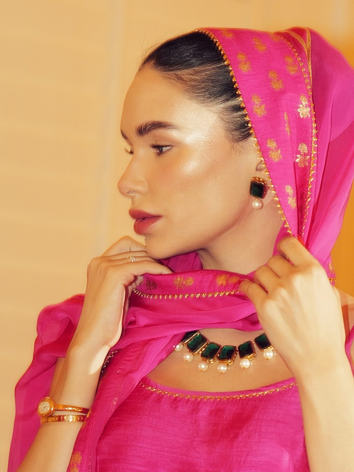 Close portrait of Jamillette in a fuchsia dupatta with gold trim and an emerald necklace