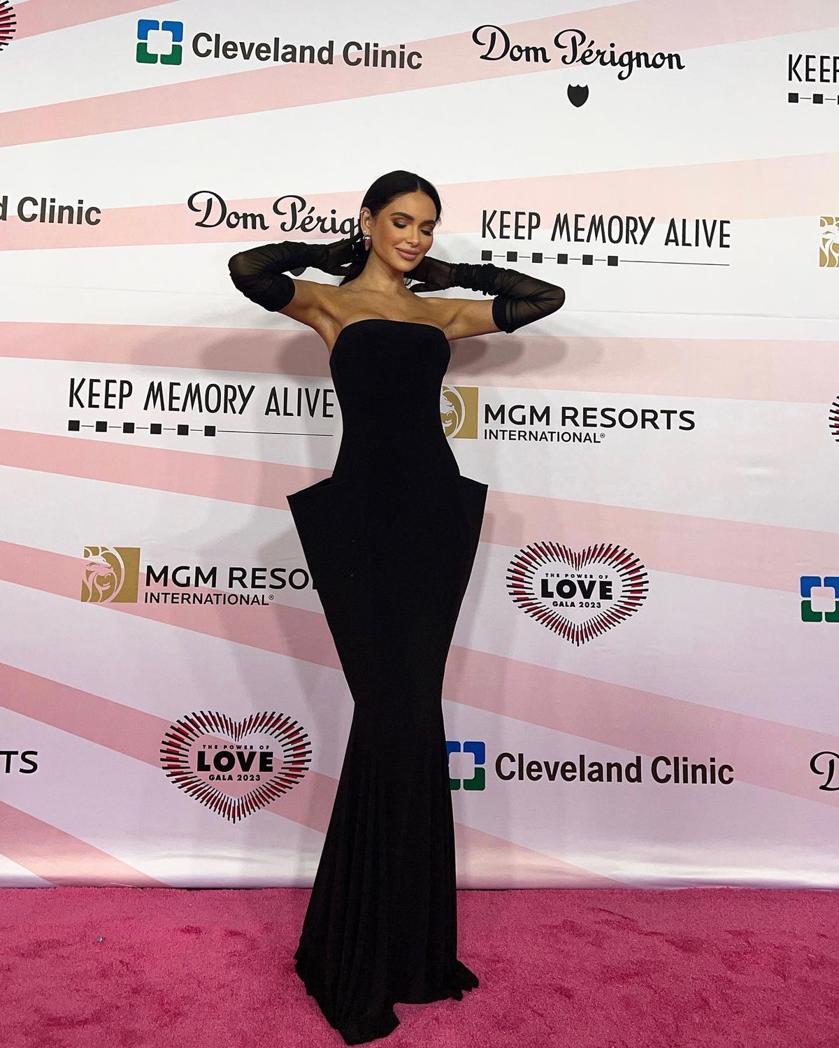 Jamillette in a black strapless column gown and sheer black gloves on the gala’s pink carpet